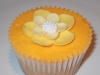 Vanilla cupcake with an Orange coloured, vanilla butter cream and a yellow flower